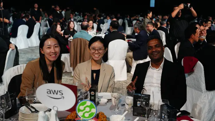 Three attendees smiling for a photograph at the SSIA Semiconductor Dinner 2026 in Singapore.